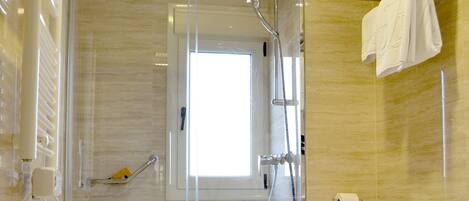 A modern bathroom with a glass-enclosed shower, a toilet, and a towel rack.