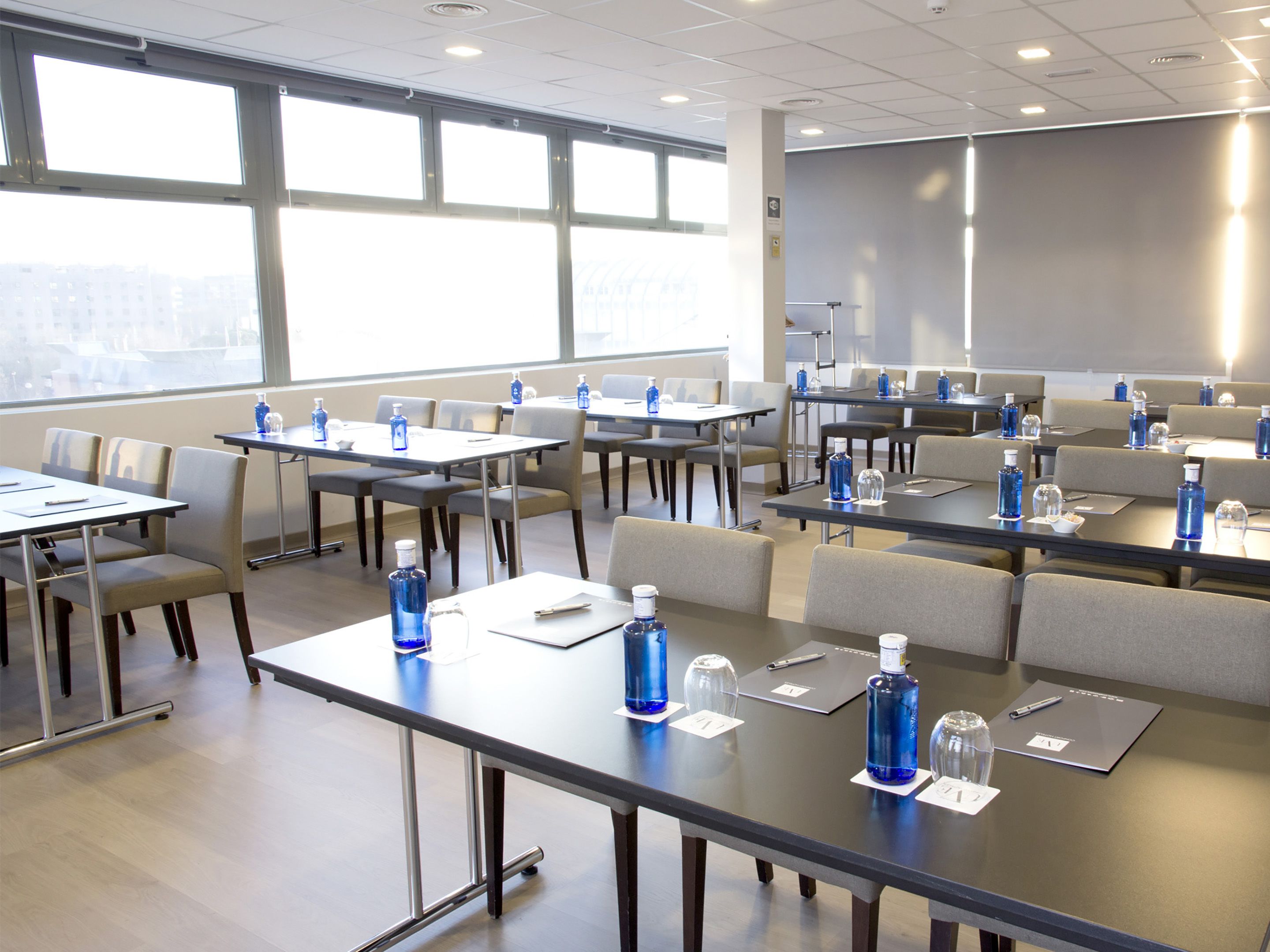 A conference room with tables, chairs, and water bottles.