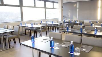 A conference room with tables, chairs, and water bottles.
