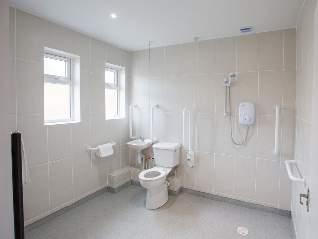Un baño moderno con inodoro, lavamanos y ducha.