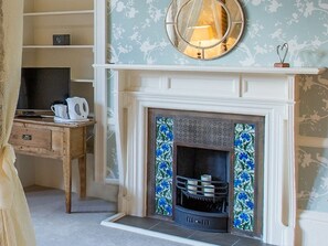 A room with a fireplace, a wooden desk, and a mirror above it. - Balcary House Hotel (Hawick)