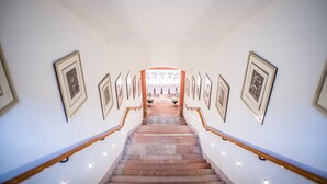 Una escalera con cuadros en las paredes que conduce a una habitación luminosa con vistas.