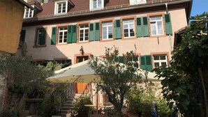 Un edificio europeo tradicional con un techo pronunciado, ventanas de tejado y un balcón.