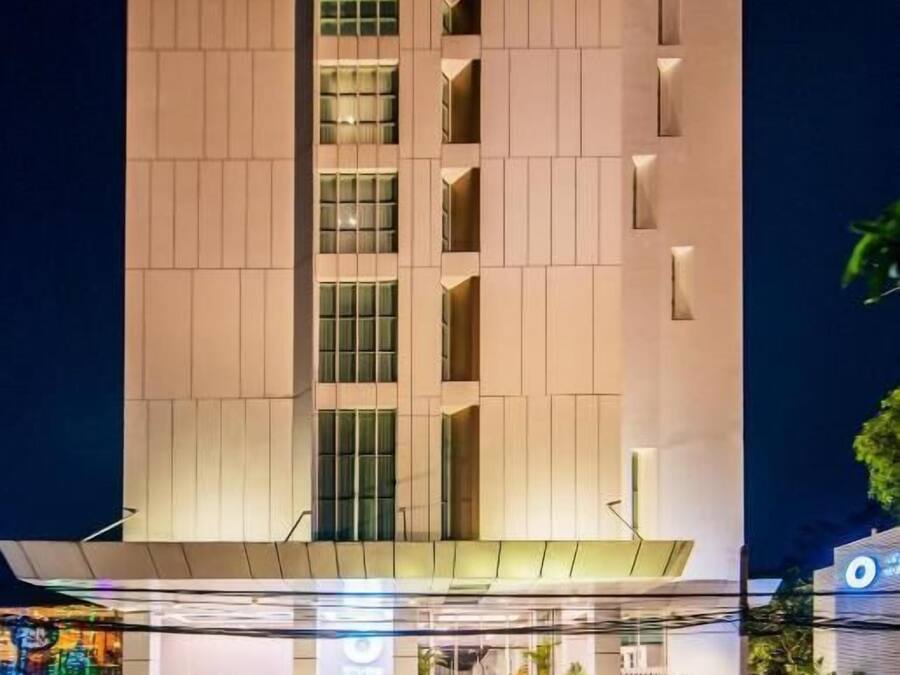 A modern hotel with a central atrium, multiple floors, and a well-lit entrance.