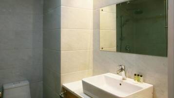 Uma casa de banho moderna com um espelho grande, uma sanita branca e uma casa de toilette.