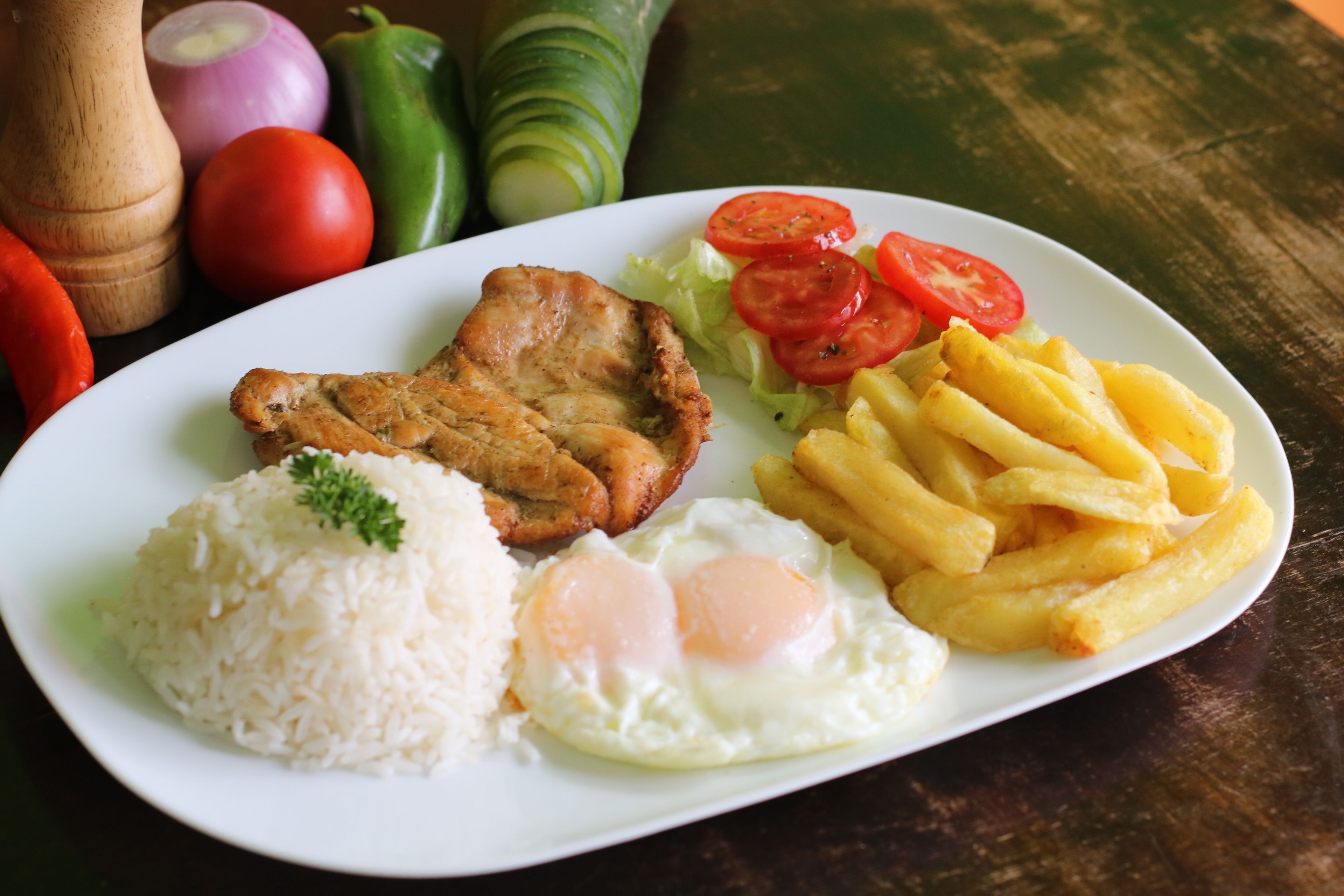 A plate of food with rice, eggs, and French fries.