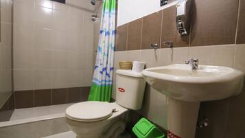 Baño con inodoro, lavabo y cortina de ducha.