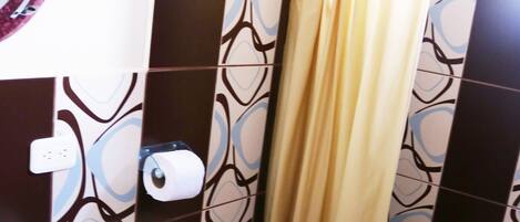 A bathroom with a toilet, sink, and shower curtain.