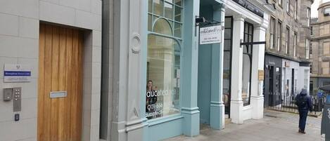 A building with a sign for 'Educated Food Restaurant' and a wooden door on the left.