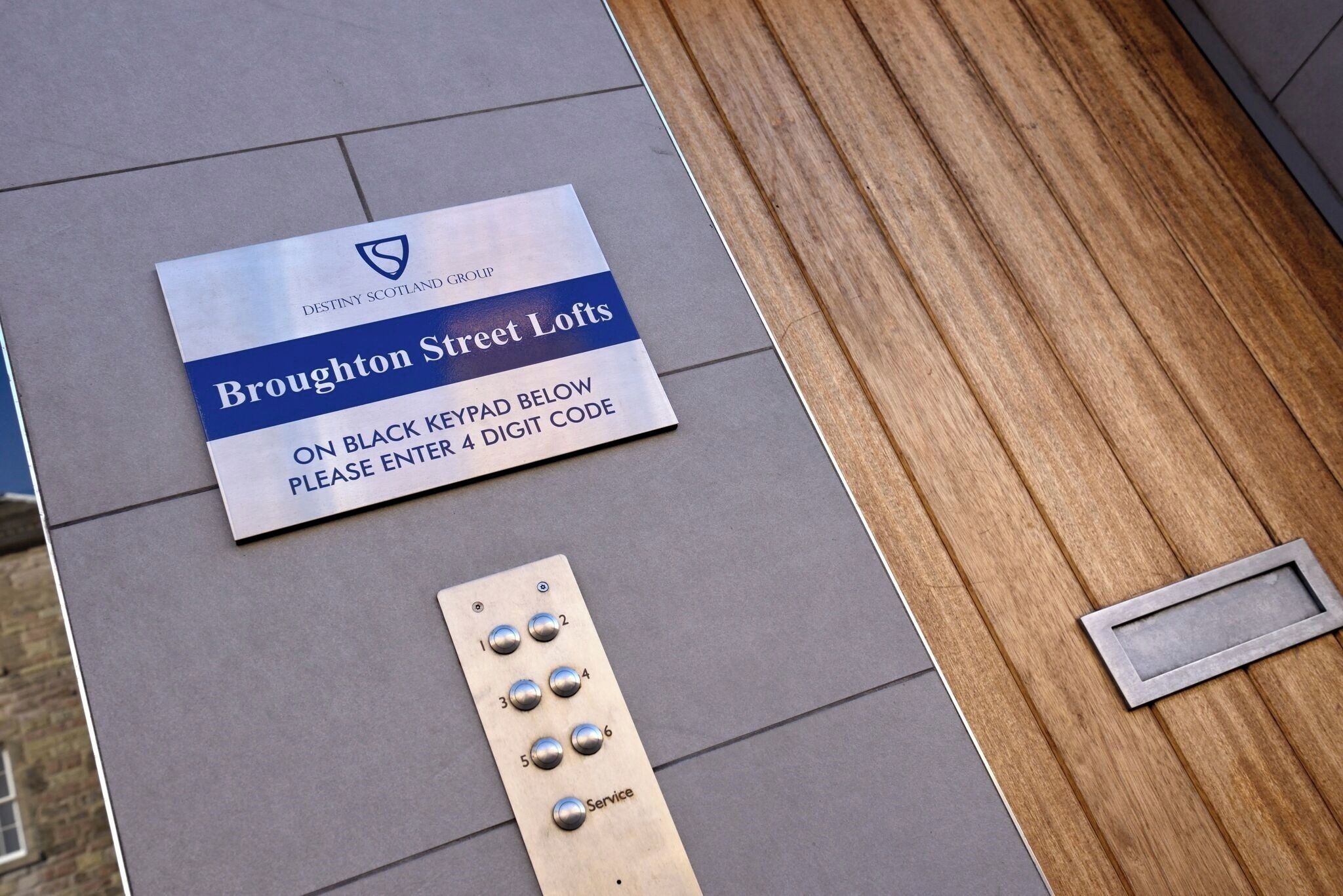 Skilt for Broughton Street Lofts med et tastatur til adgang.