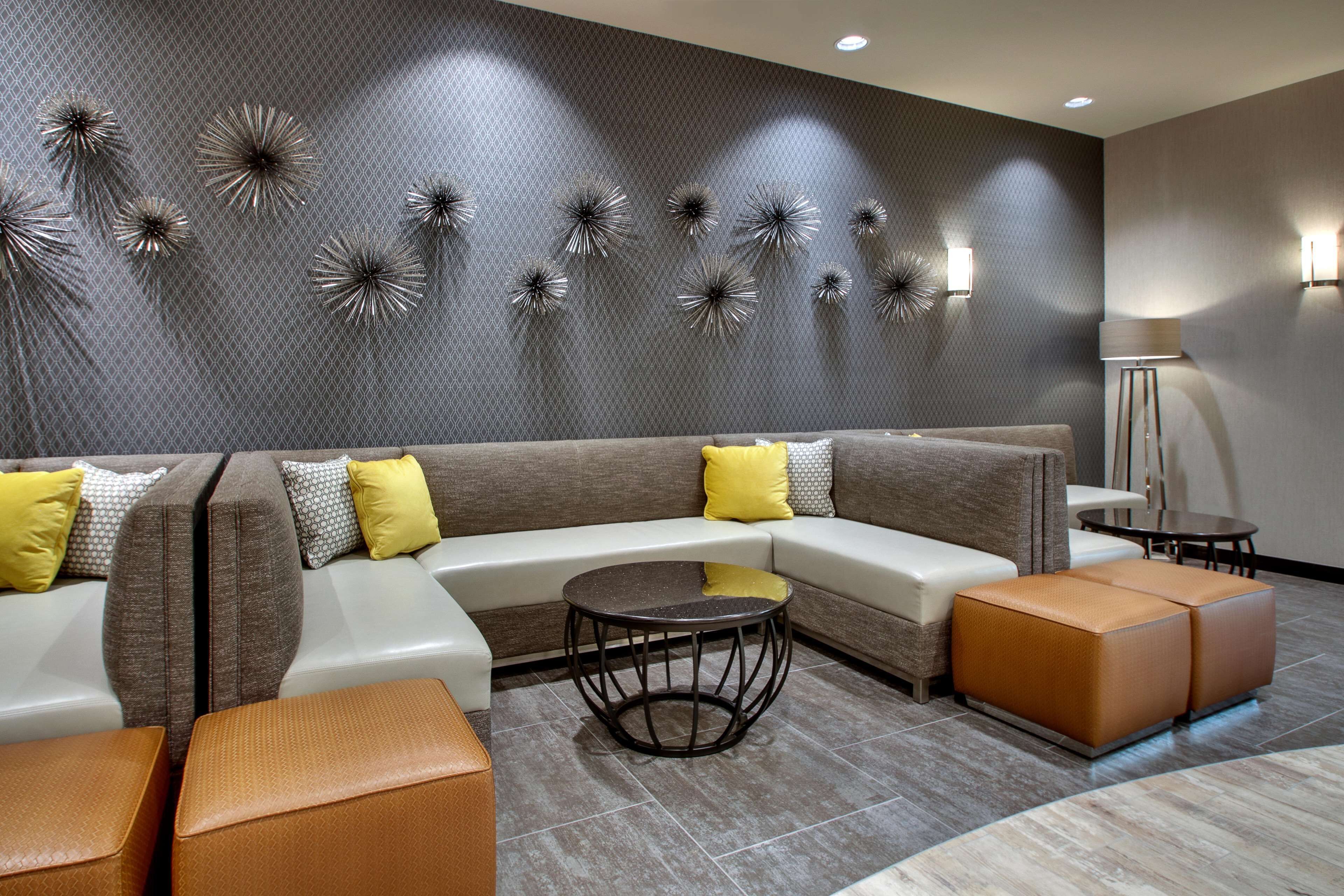 A modern living room with a sectional sofa, a round coffee table, and decorative wall art.