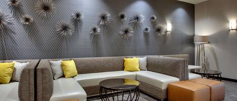 A modern living room with a sectional sofa, a round coffee table, and decorative wall art.