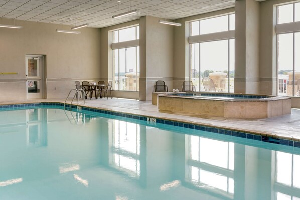An indoor swimming pool with clear blue water, surrounded by beige walls and large windows. - Drury Plaza Hotel Cape Girardeau Conference Center (Cape Girardeau)