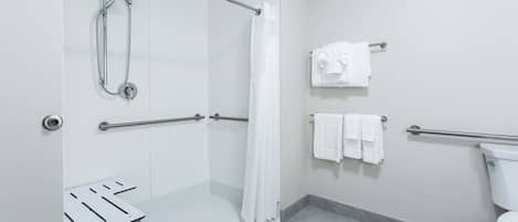 A modern bathroom with a walk-in shower, grab bars, a toilet, and a towel rack.