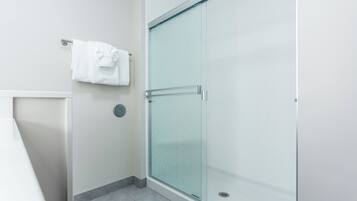 A bathroom with a glass shower enclosure, a towel rack, and a toilet.