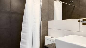 Un baño moderno con ducha, inodoro y lavamanos.