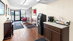 A hotel lobby with a reception desk, a coffee machine, and a self-service kiosk. - Red Roof Inn Cortland (Cortland)