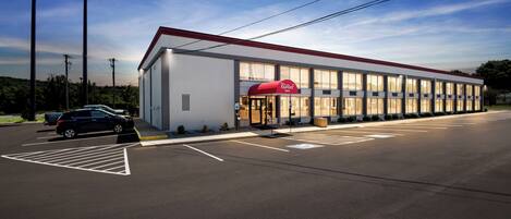 A Red Roof Inn with a modern building and a parking lot.
