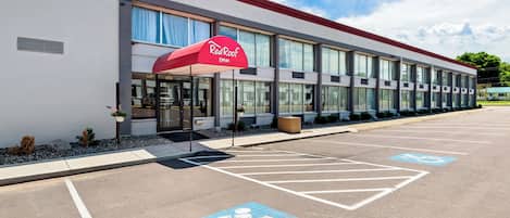 Un bâtiment de la chaîne Red Roof Inn, doté d’un parking, de places de stationnement réservées aux personnes handicapées et d’une entrée abritée.