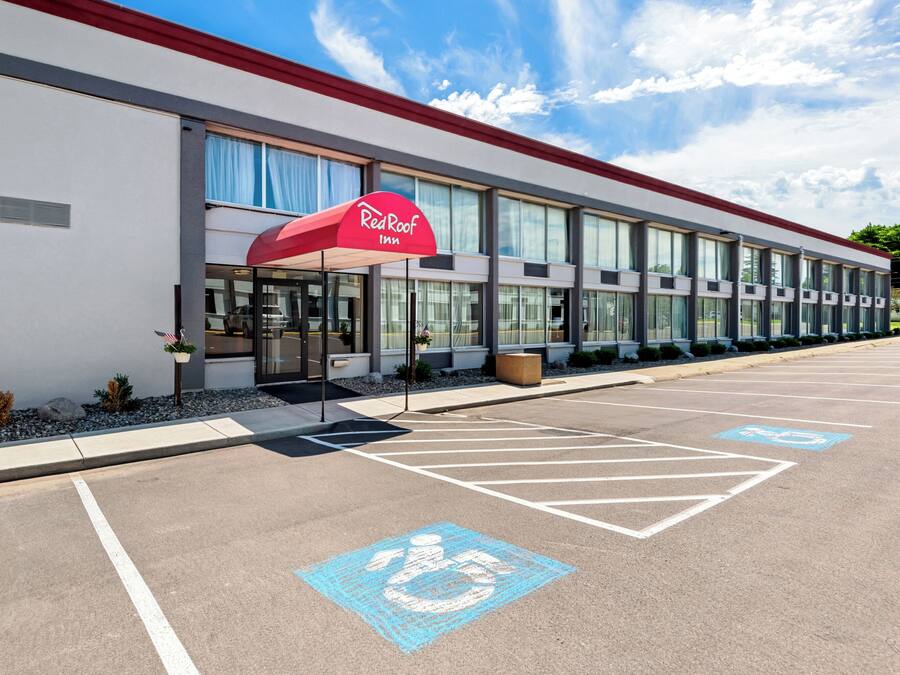 Edificio de Red Roof Inn con estacionamiento, espacios reservados para discapacitados y entrada cubierta.