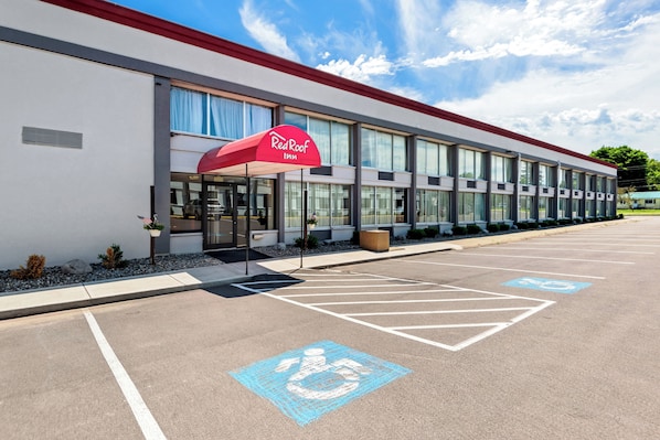 A Red Roof Inn building with a parking lot, handicap parking, and a covered entrance.