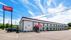 A Red Roof Inn with a parking lot and a clear blue sky. - Red Roof Inn Cortland (Cortland)
