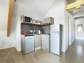 A modern kitchen with a built-in microwave, coffee maker, and refrigerator. - Apartment in French Alps with Heated Pool (La Salle les Alpes)