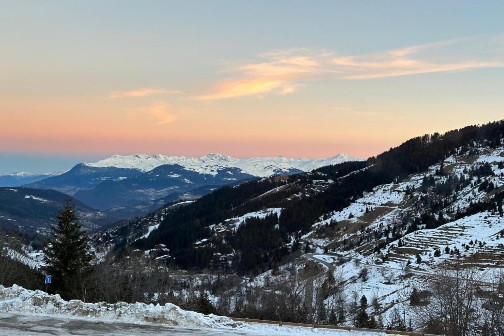 A snow-covered mountain landscape with a winding road.