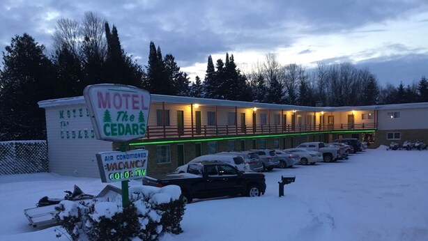 Motel con cartel que indica aire acondicionado, habitaciones disponibles y televisión en color.