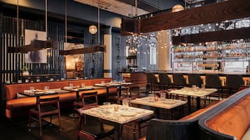 A restaurant interior with booths, tables, and a bar area.