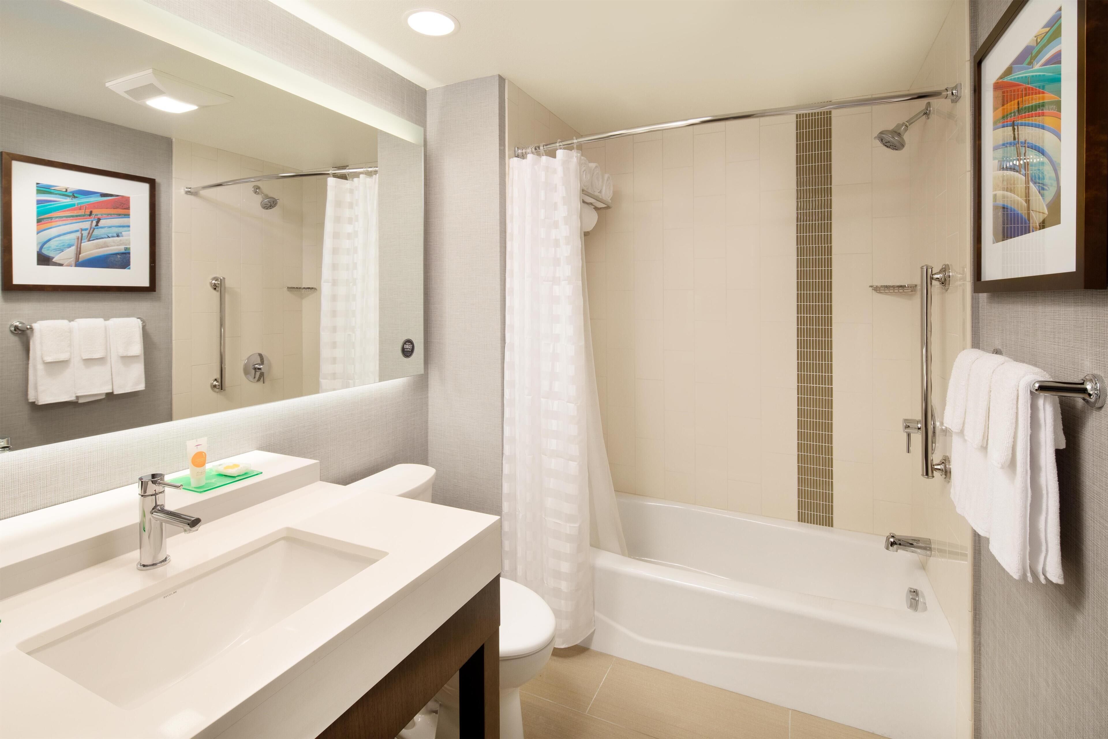 A bathroom with a sink, toilet, shower, and bathtub.