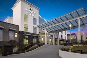 A Hyatt Place hotel entrance with a covered walkway, a clear sky, and a well-lit facade. - Hyatt Place Santa Cruz (Santa Cruz)