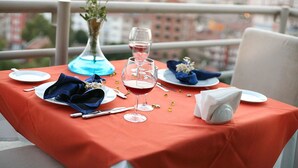 A table set for two with a red tablecloth, white plates, blue napkins, and a vase with white flowers. - Hotels Dalgiclar (Corum)