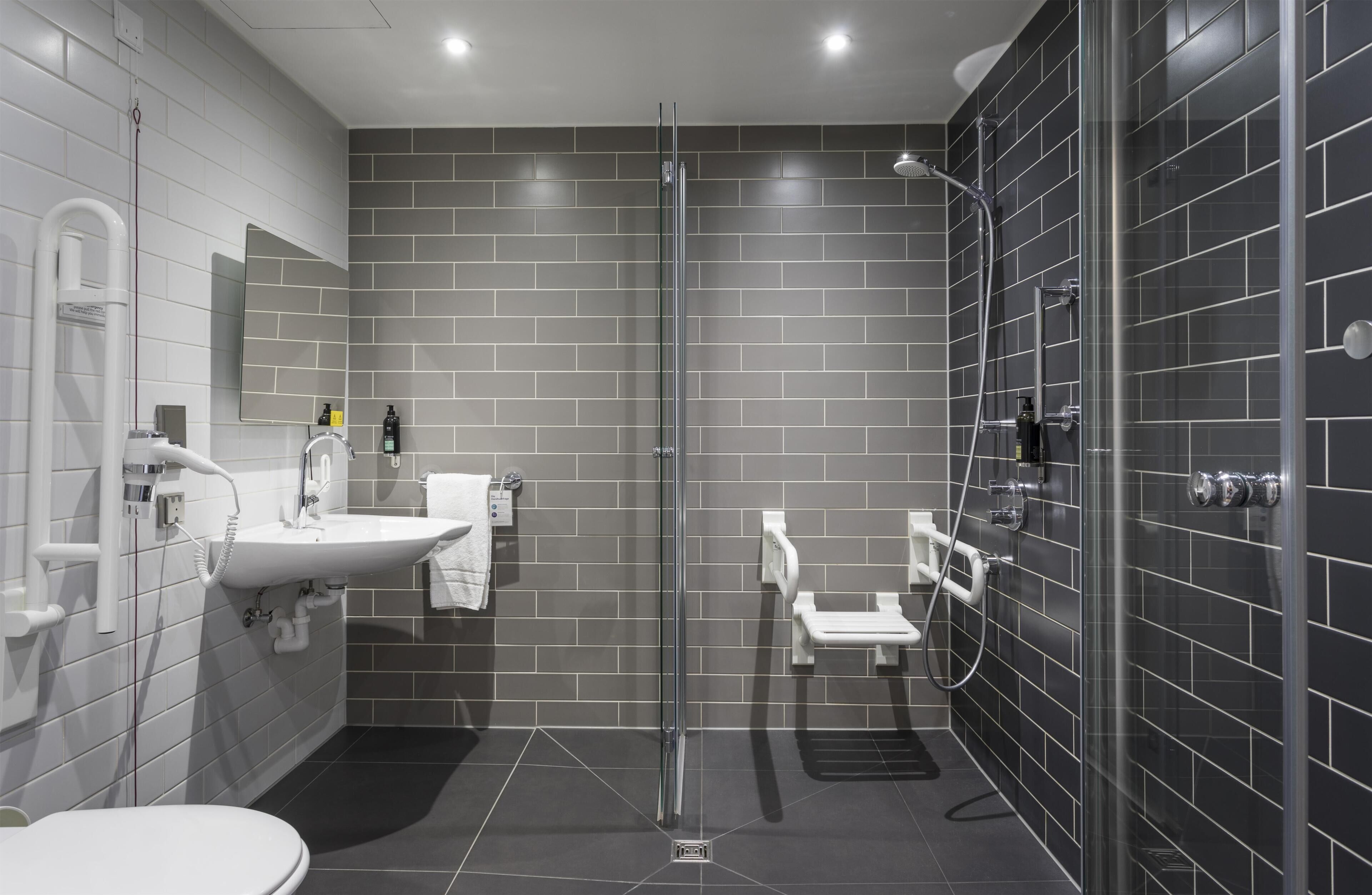 A modern bathroom with a glass-enclosed shower, a sink, and a toilet.