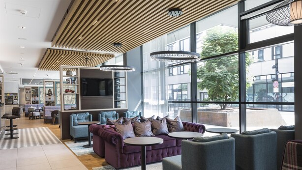 Un interior moderno con un sofá, sillones y un televisor.