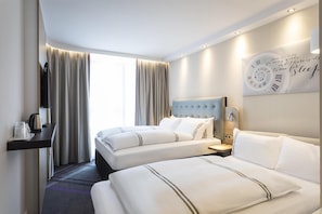 A hotel room with two beds, a TV, a clock, and a window with curtains. - Premier Inn Freiburg City Süd (Freiburg im Breisgau)