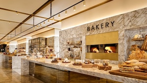 A bakery counter with marble countertops, a fireplace, and various baked goods displayed.