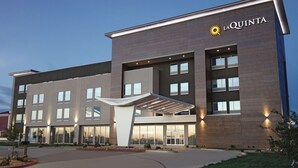 Un hôtel moderne, reconnaissable à son grand panneau « La Quinta », à ses larges fenêtres et à son entrée abritée.