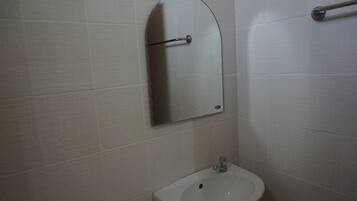 A bathroom with a white sink, a mirror, and a towel rack.