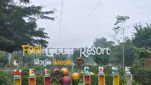 A sign for a resort with colorful plant displays and a Thai translation. - Feel Good Resort (Nakhon Ratchasima)
