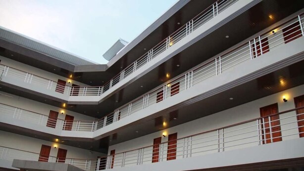 A multi-story building with balconies, large windows, and a modern architectural design. - Grand Perfect Apartment (Udon Thani)