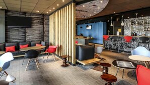 Un intérieur moderne avec un espace bar, des coins salon et un plafond orné de motifs.