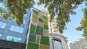 Een modern gebouw met een glazen gevel en een verticale groene geveltuin.