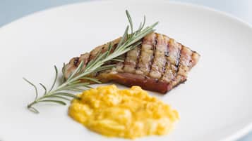 Ein Teller mit gegrilltem Steak und Rührei, garniert mit Rosmarin.