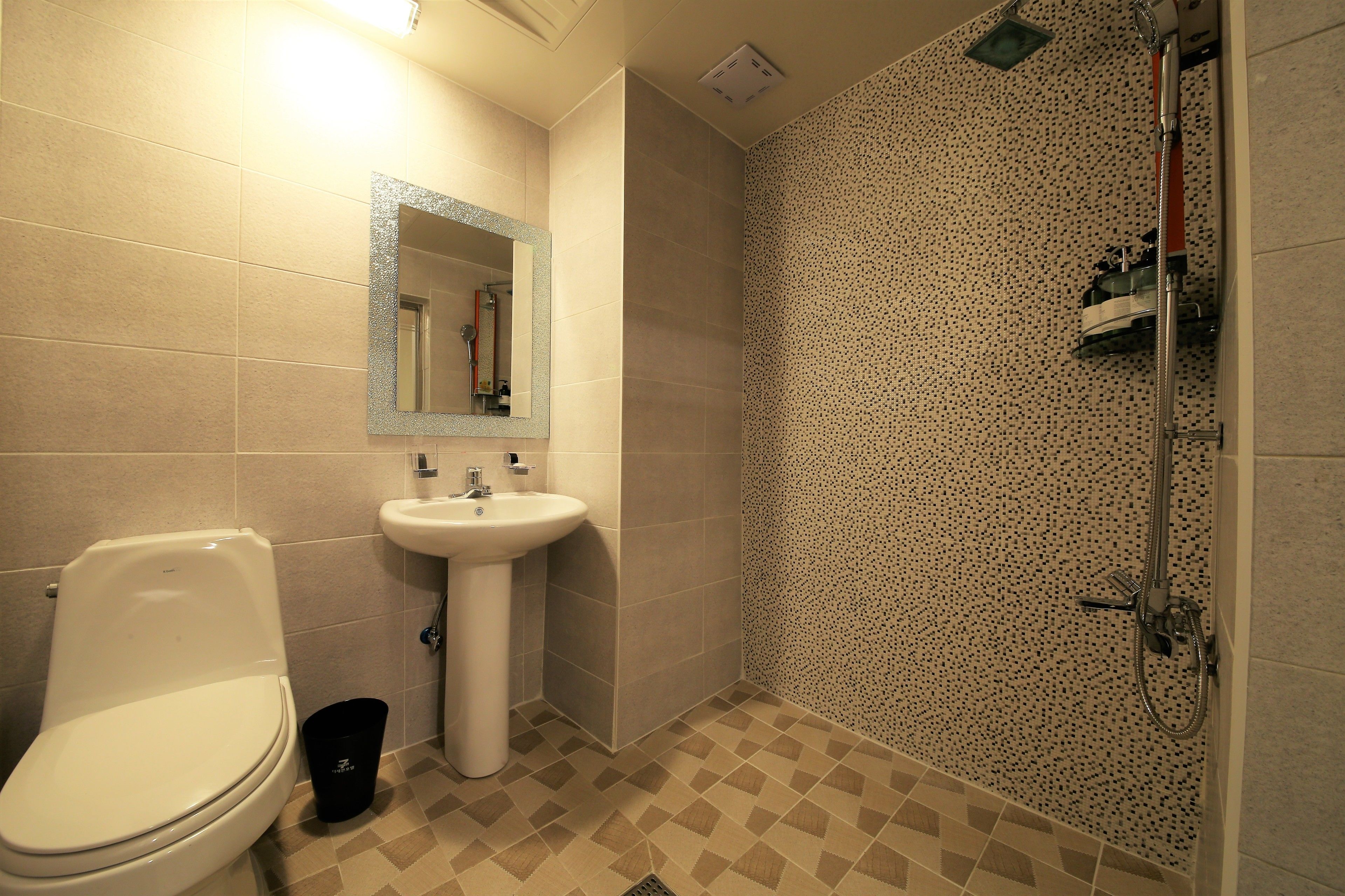 A bathroom with a toilet, sink, and shower.