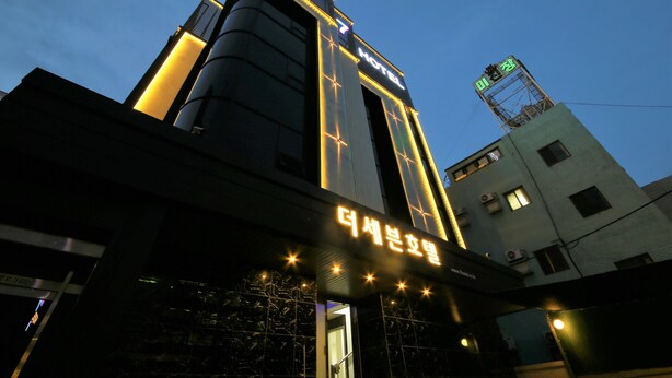 A hotel with a prominent sign reading "THE HOTEL" and a smaller sign below it.