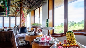 A buffet setup with various dishes and a large pineapple centerpiece.