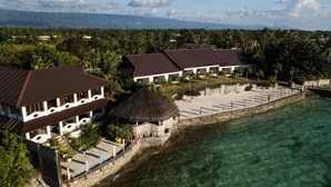 A resort with multiple buildings, clear waters, and a beach area.