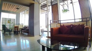 Un interior moderno con una mesa de centro de vidrio, un sofá rojo y un comedor con sillas y una mesa.