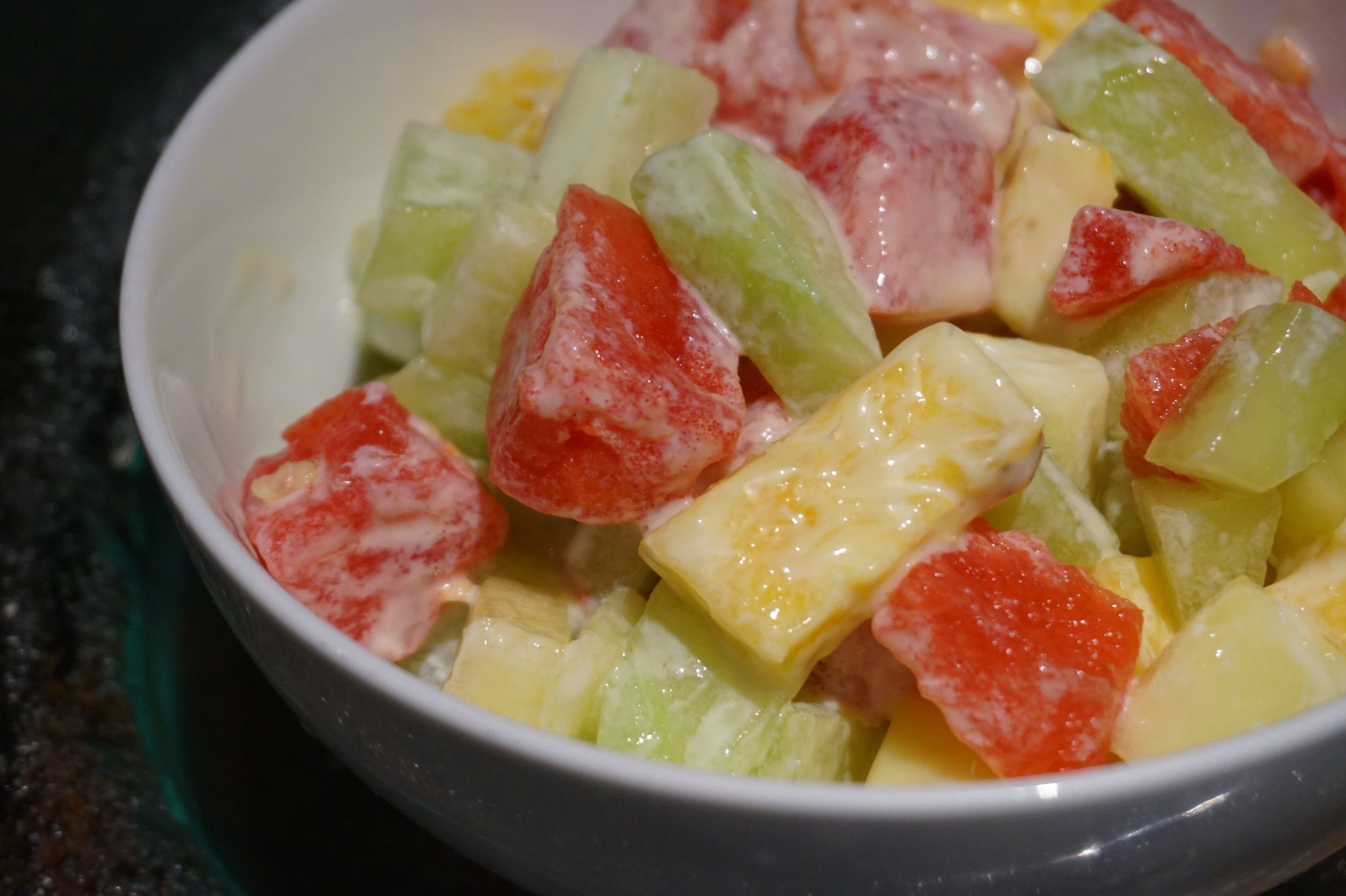 A bowl of fruit salad with various diced fruits.
